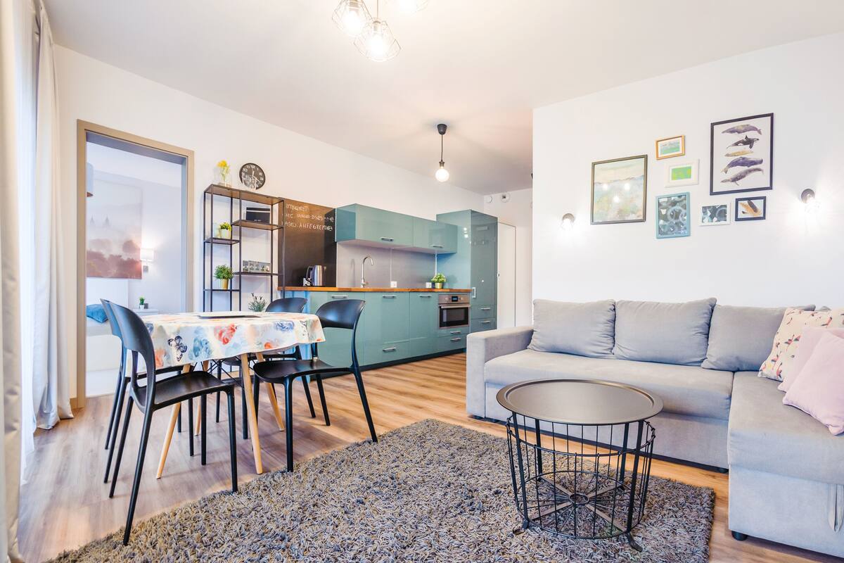A compact living space with a dining area, kitchenette, and a sofa.