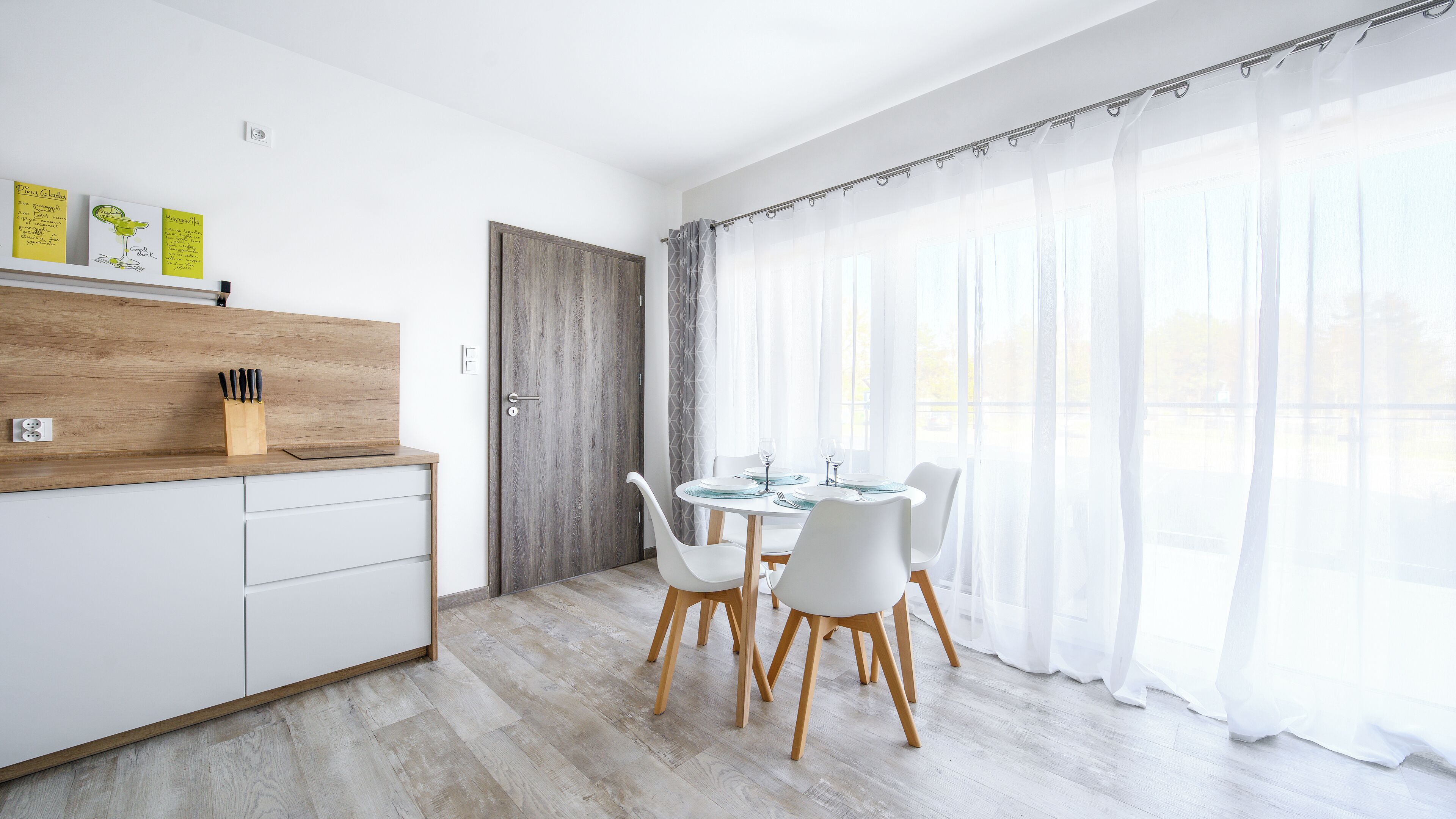 Eine moderne Küche mit weißen Schränken, einer Holzauskładung und einem Messerblock.
