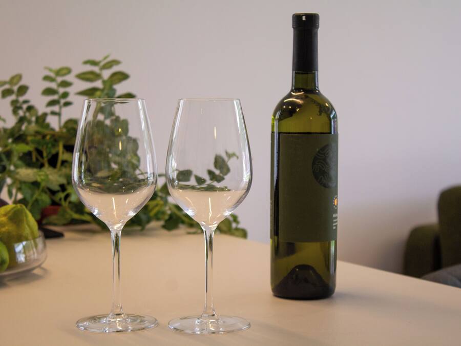 Two empty wine glasses and a bottle of wine on a table.