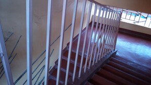 A staircase with a metal railing, leading to an upper floor. - Kings Guest House (Kabati)