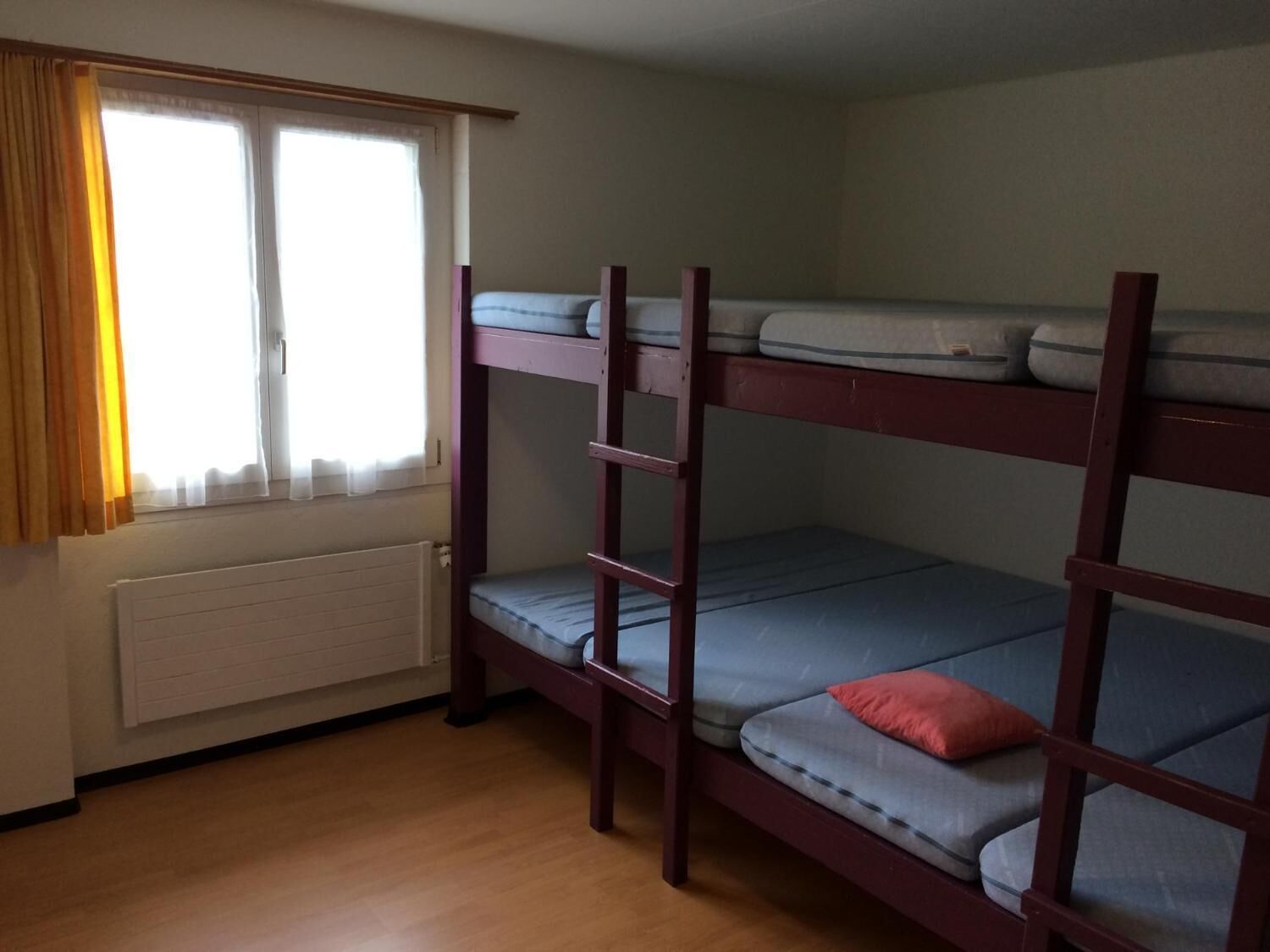 Dormitorio con literas, ventana y cortinas.