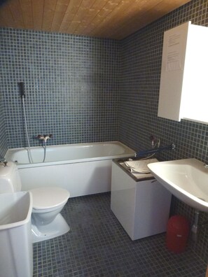 A bathroom with a bathtub, toilet, and sink. - Appartement Emeraude 615 (Ayent)