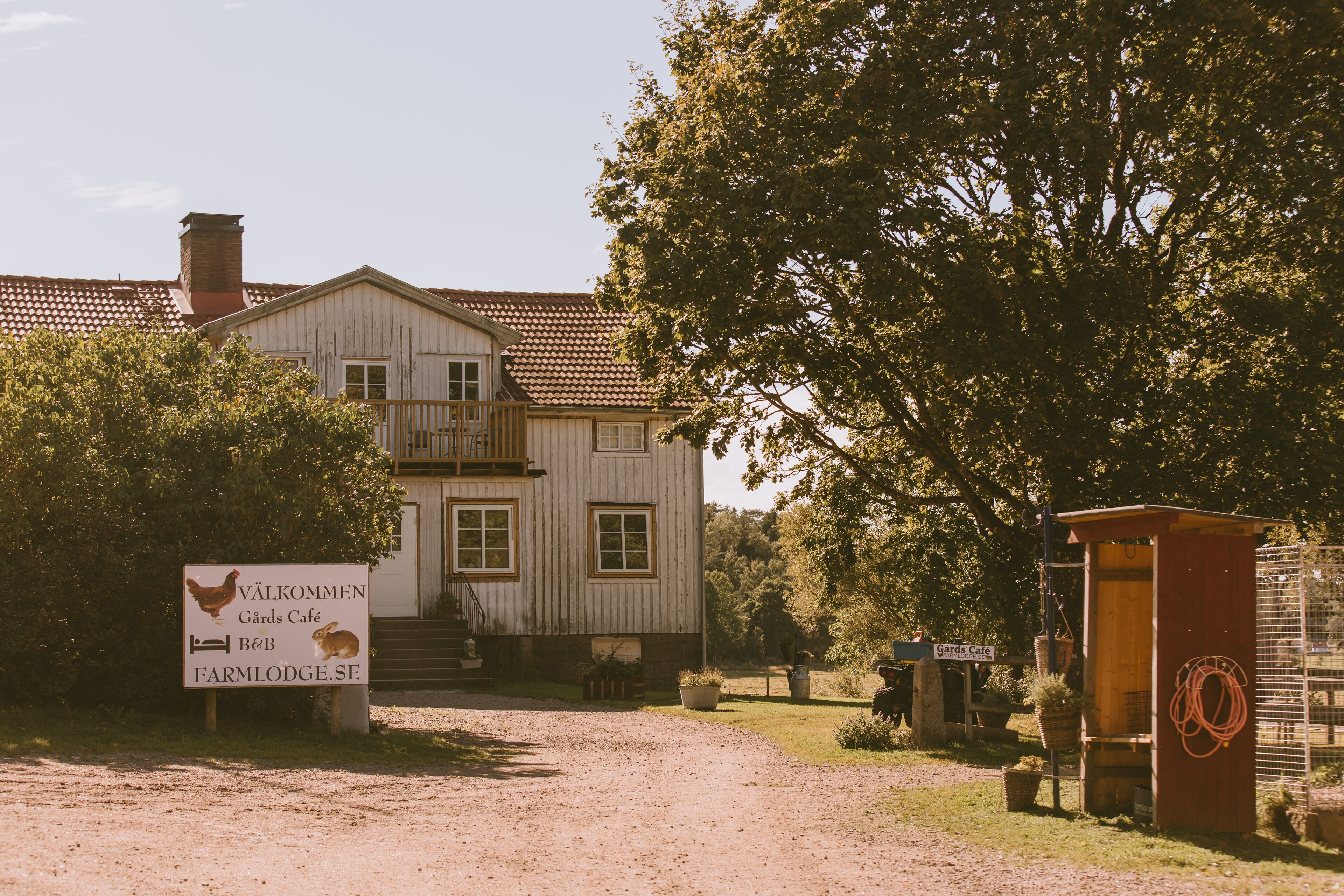 A rustic building with a sign indicating a farm lodge and cafe.