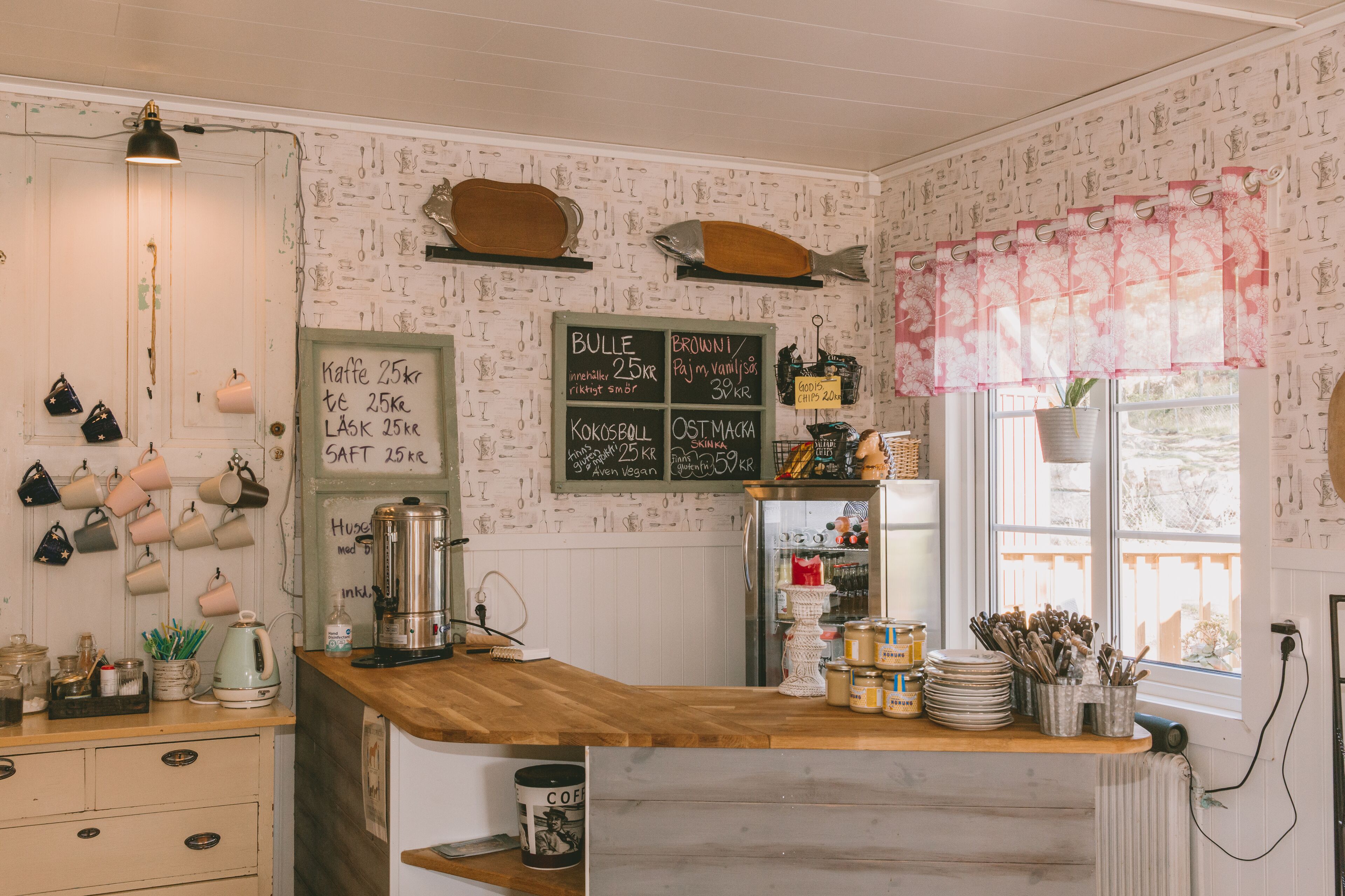 L’intérieur d’un café chaleureux, avec un comptoir en bois, un tableau noir servant de menu et divers ustensiles de cuisine.