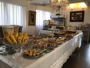 Una mesa de buffet con diversos alimentos y una máquina de café al fondo.