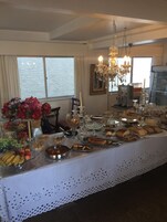 Un bufé de desayuno con diversas opciones de comida y una araña de cristal.