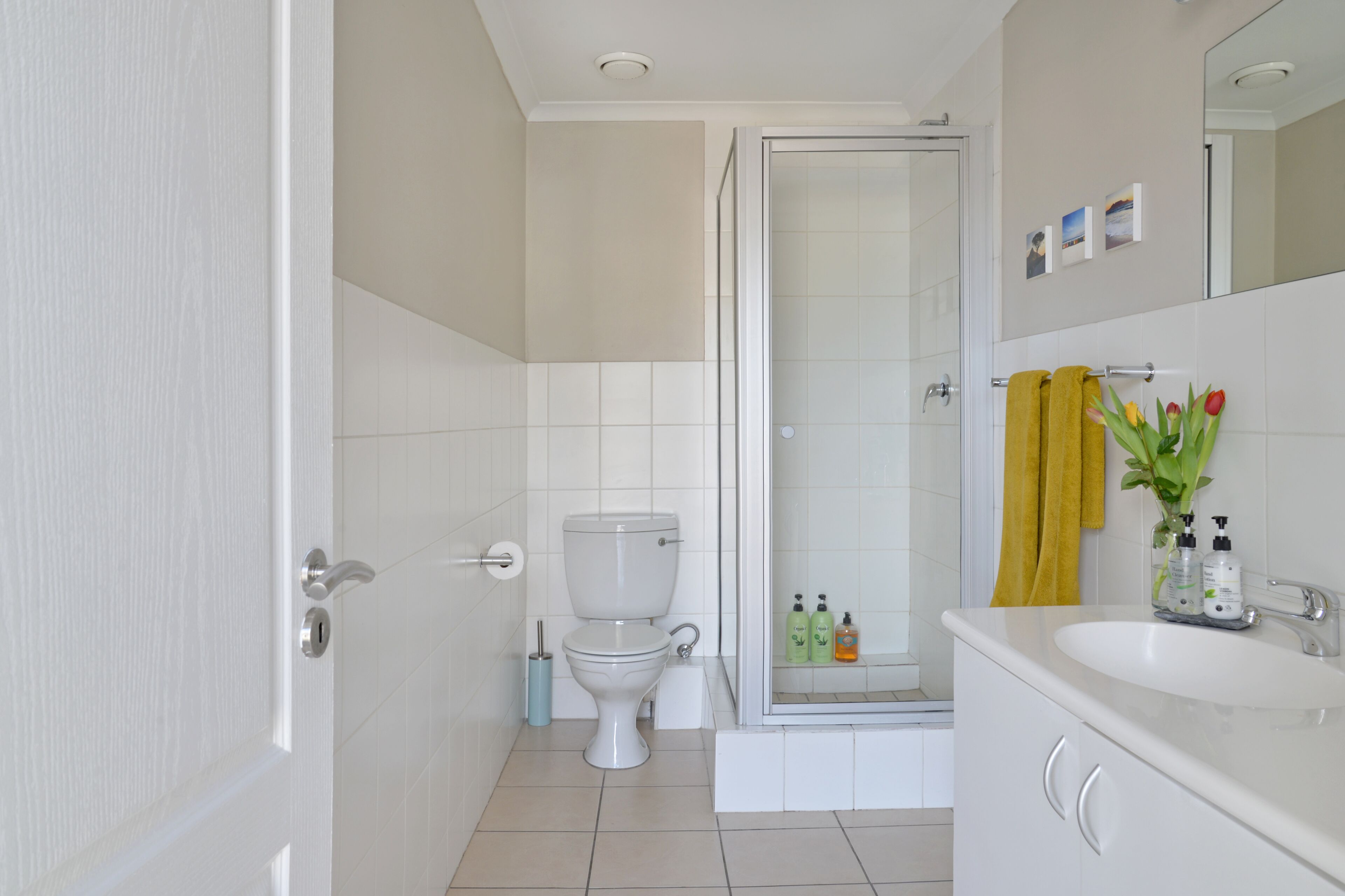 A modern bathroom with a toilet, shower, and sink.