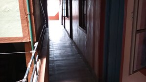 A narrow hallway with a metal railing on one side and a blue door on the other. - Haricot Guest House (Murang'a)