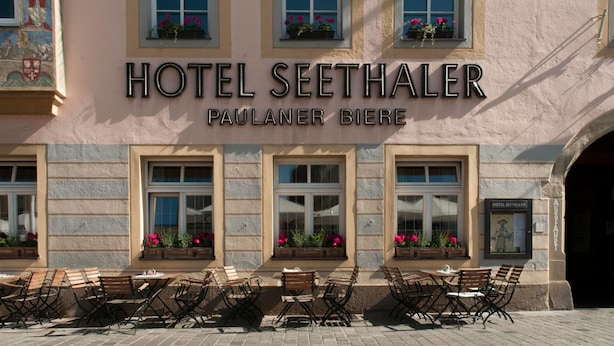 El exterior del Hotel Seethaler, con fachada tradicional, amplias ventanas con jardineras y zona de estar al aire libre.