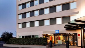 Un hotel de varios pisos con un cartel que dice 'ibis budget'.