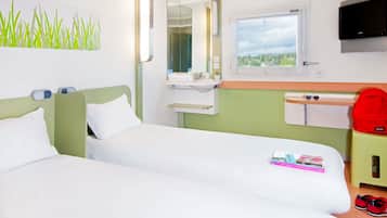 A hotel room with two beds, a bathroom, a TV, and a window with a view.