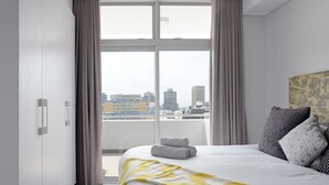 A hotel room with a large bed, a view of the city, and a balcony. - Zara By Stay Amazing (Cape Town)