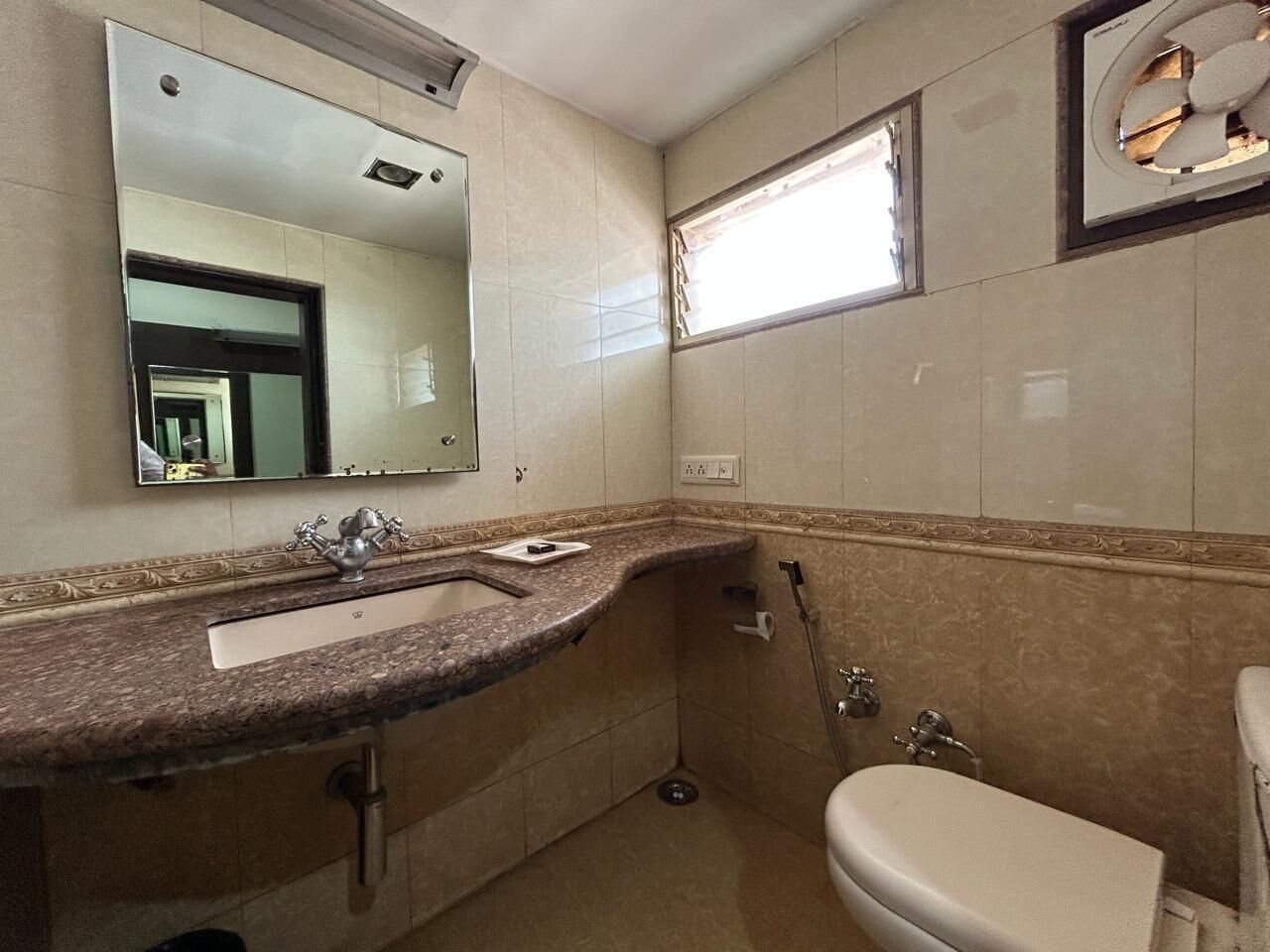 Un bagno con lavandino, specchio e water.