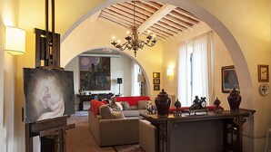 Un salon chaleureux avec une cheminée, un canapé, une table basse et un lustre.