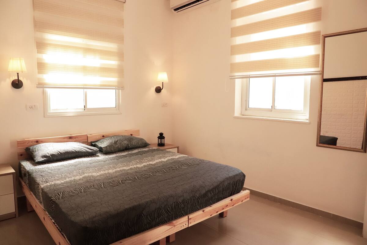 Escritorio, cortinas blackout y tabla de planchar con plancha