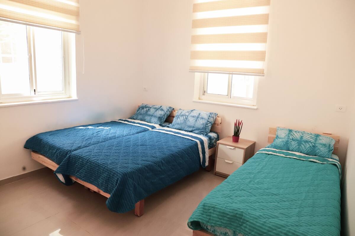 Escritorio, cortinas blackout y tabla de planchar con plancha