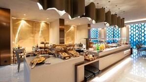 A modern breakfast bar with a variety of food options and a view of the city.