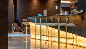 A modern bar area with a curved counter and bar stools.