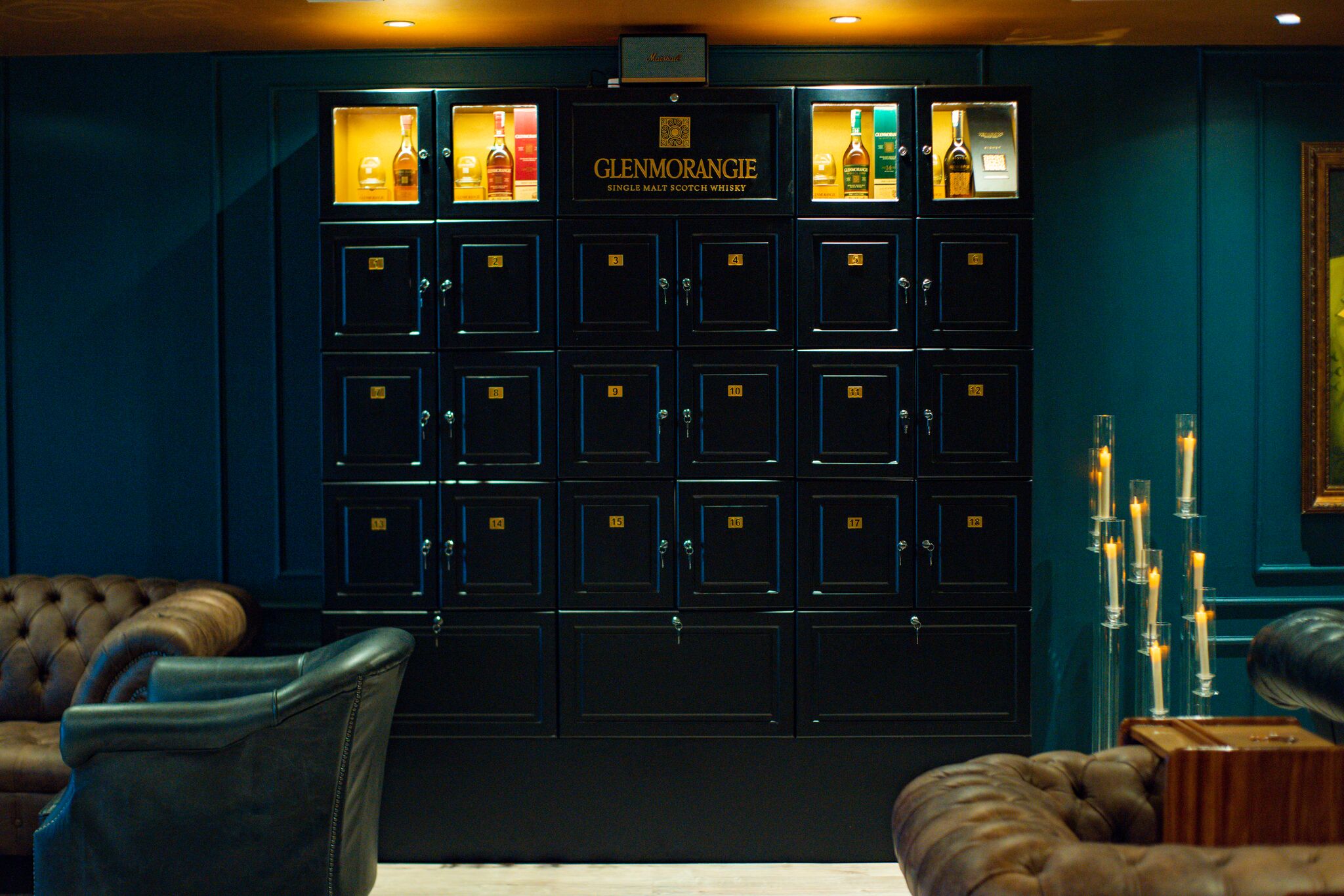 A row of black lockers with a sign above them reading "Glenmorangie Single Malt Scotch Whisky."