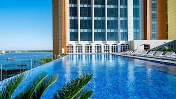 Una piscina al aire libre, sillones reclinables de piscina