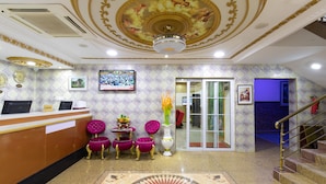 A reception area with a marble floor, a reception desk, and a staircase. - AG Hotel and Suites (Accra)
