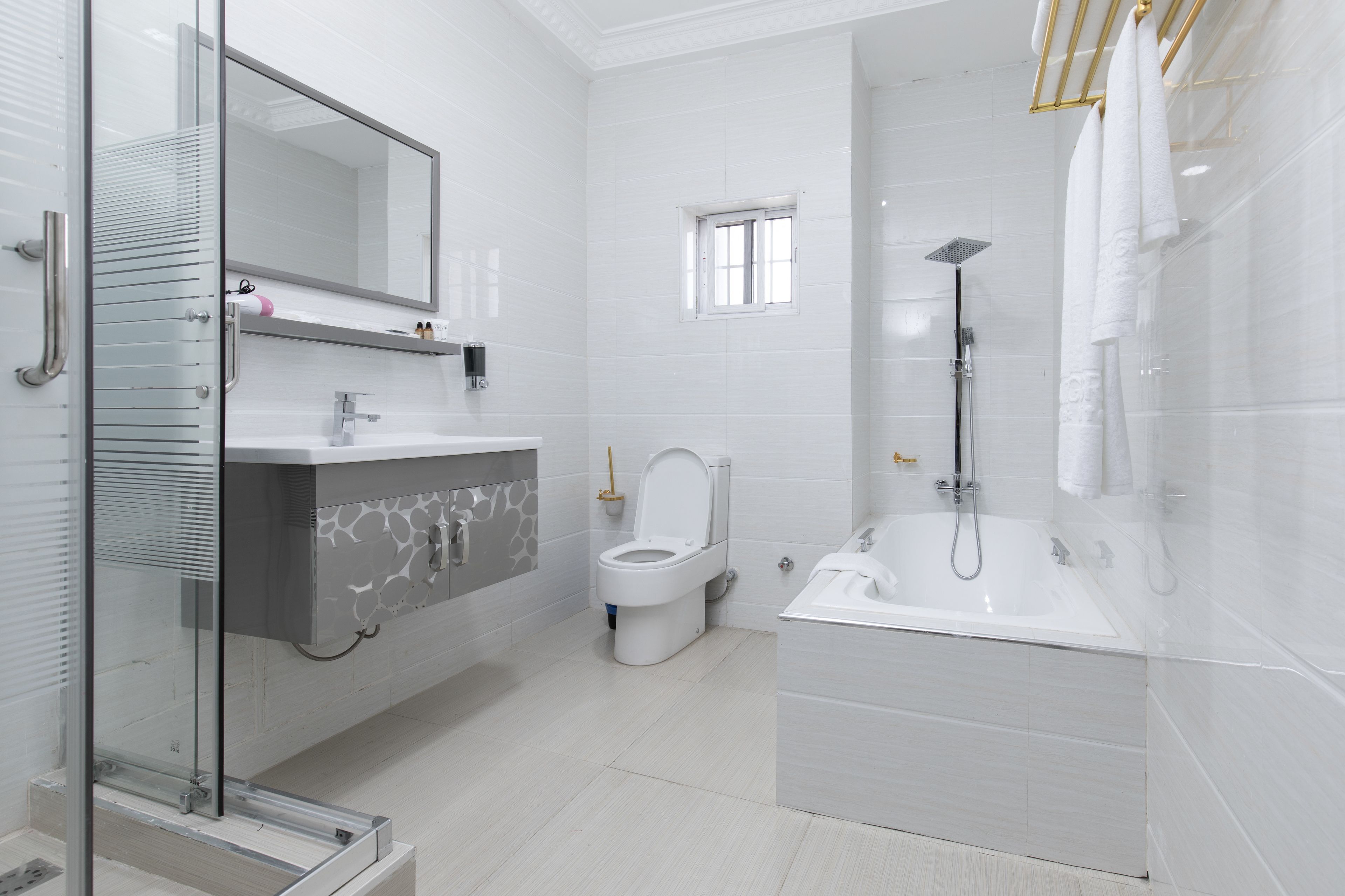 Un baño moderno con cabina de ducha de vidrio, inodoro blanco y bañera.