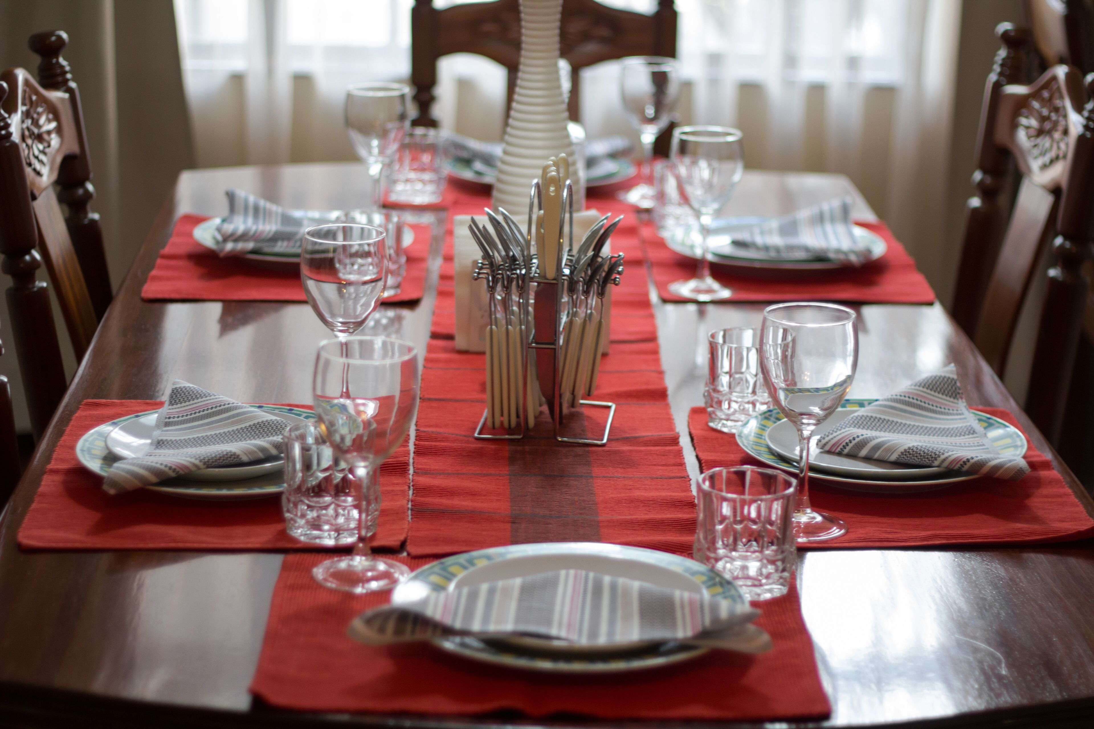 A dining table set with plates, glasses, and cutlery.