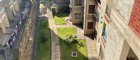 A courtyard with a pathway, a clothesline, and a small garden area.