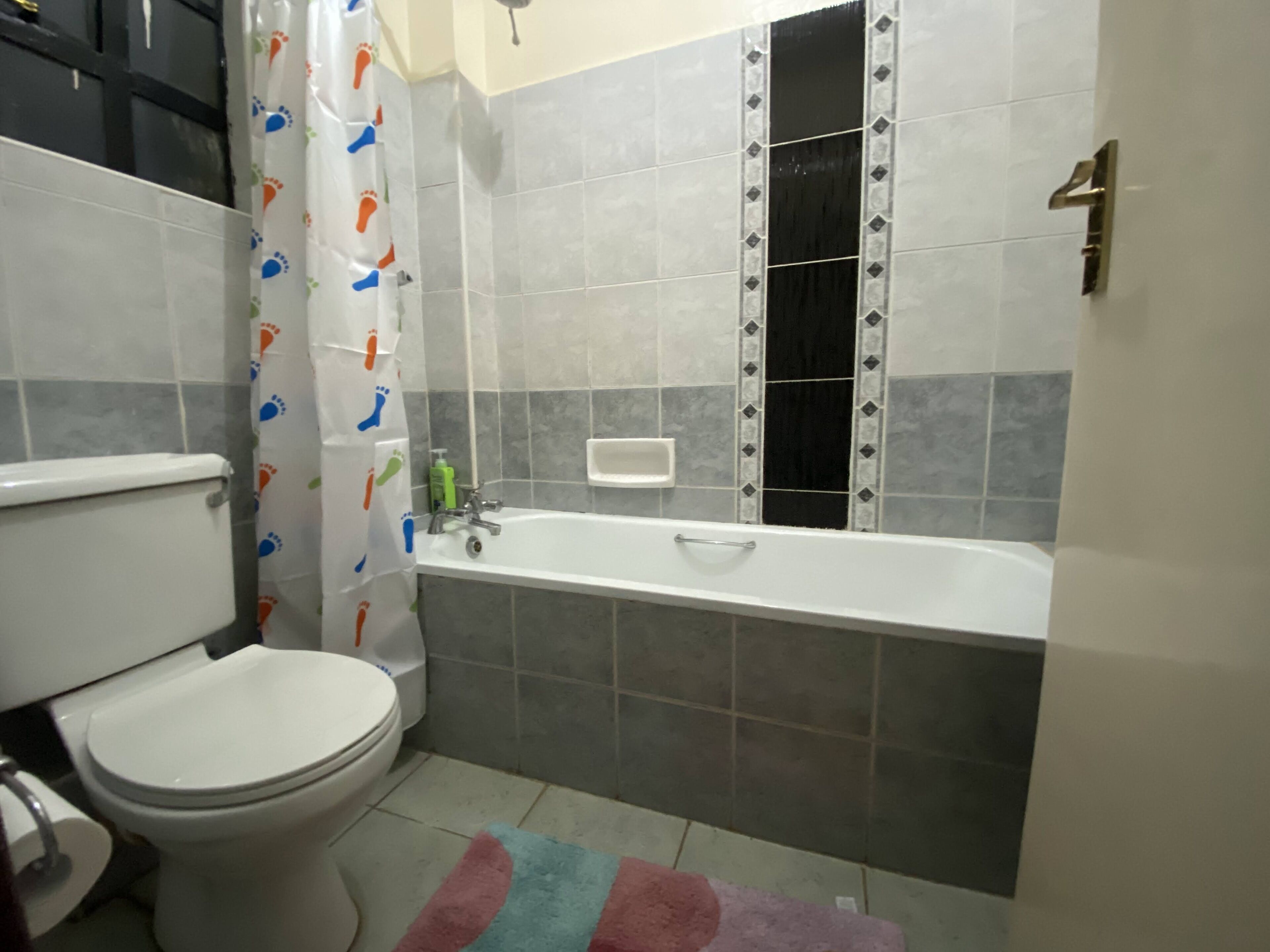 Un baño con inodoro, bañera y cortina de ducha.