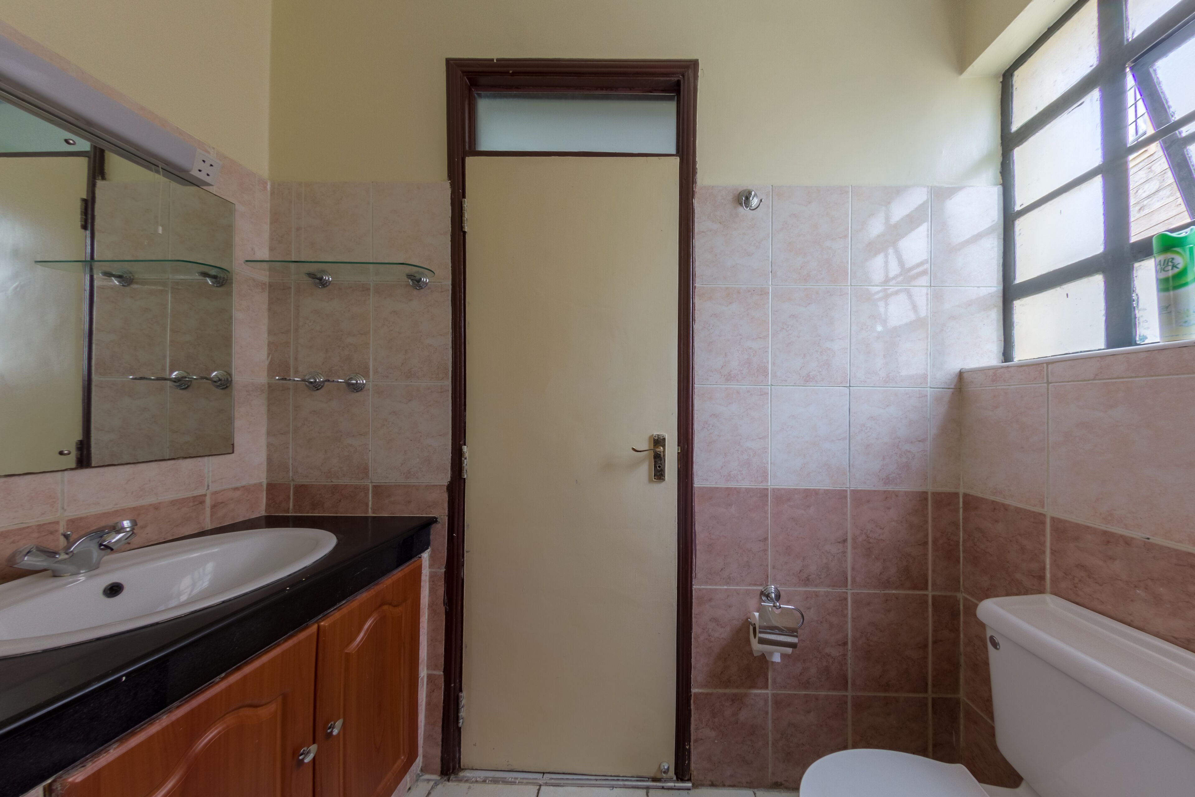 Une salle de bain avec un lavabo, un miroir et des toilettes.