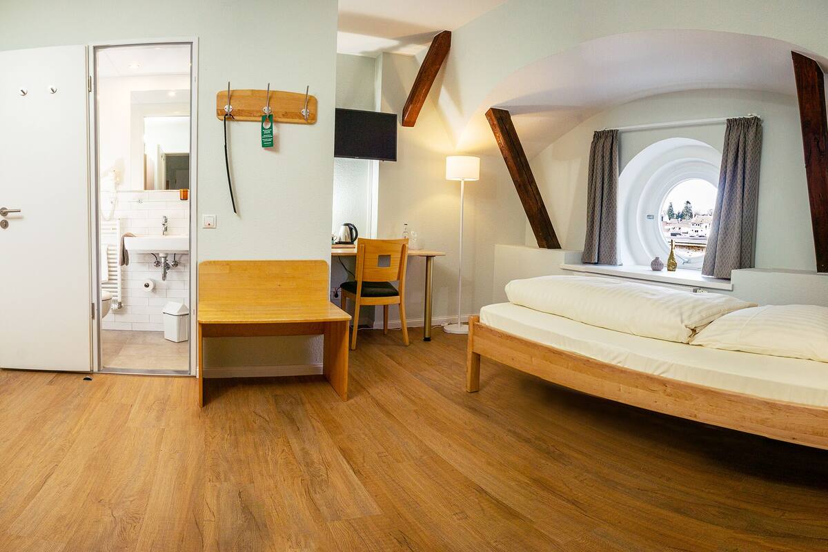 Ein Schlafzimmer mit einem Holzbett, einem Schreibtisch und einem Stuhl.