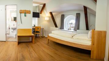 A bedroom with a wooden bed, a desk, and a chair.