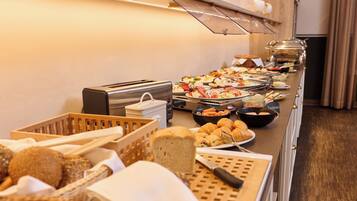 A buffet with various food items, a toaster, and a knife on a table.