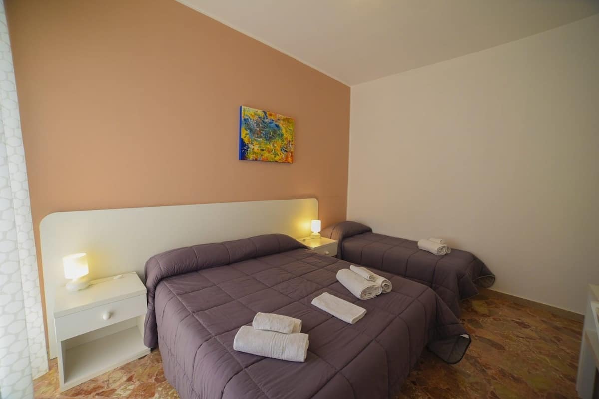 Ein Hotelzimmer mit zwei Betten, einem Nachttisch mit Lampe und einem Bild an der Wand.