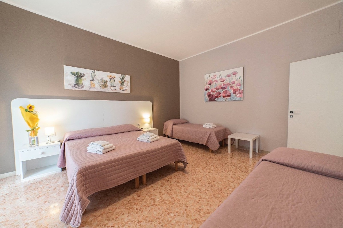 Ein Hotelzimmer mit zwei Betten, einem kleinen Nachttisch und einer Tür.