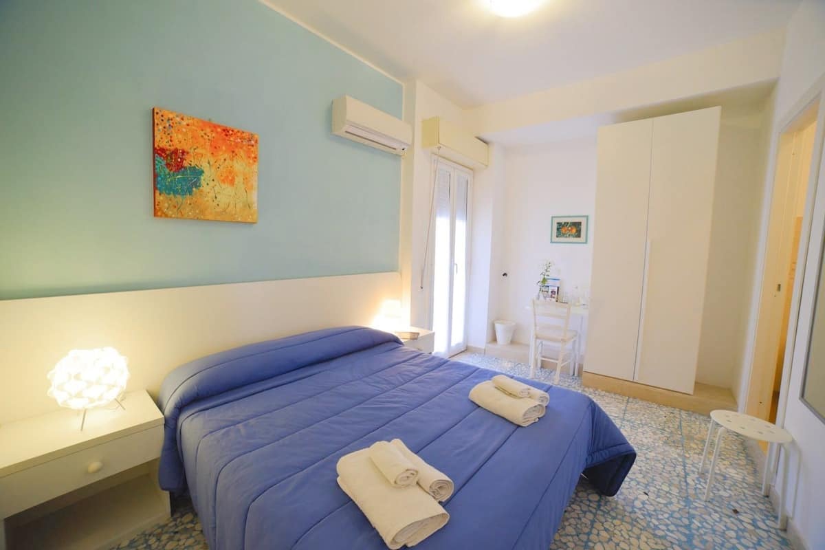 Ein Schlafzimmer mit Bett, Nachttisch und Stuhl.