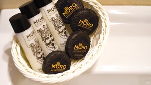 A basket containing various Moró Natura di Sicilia products including bottles and soap bars. - B&B Siracusa Holidays (Syracuse)