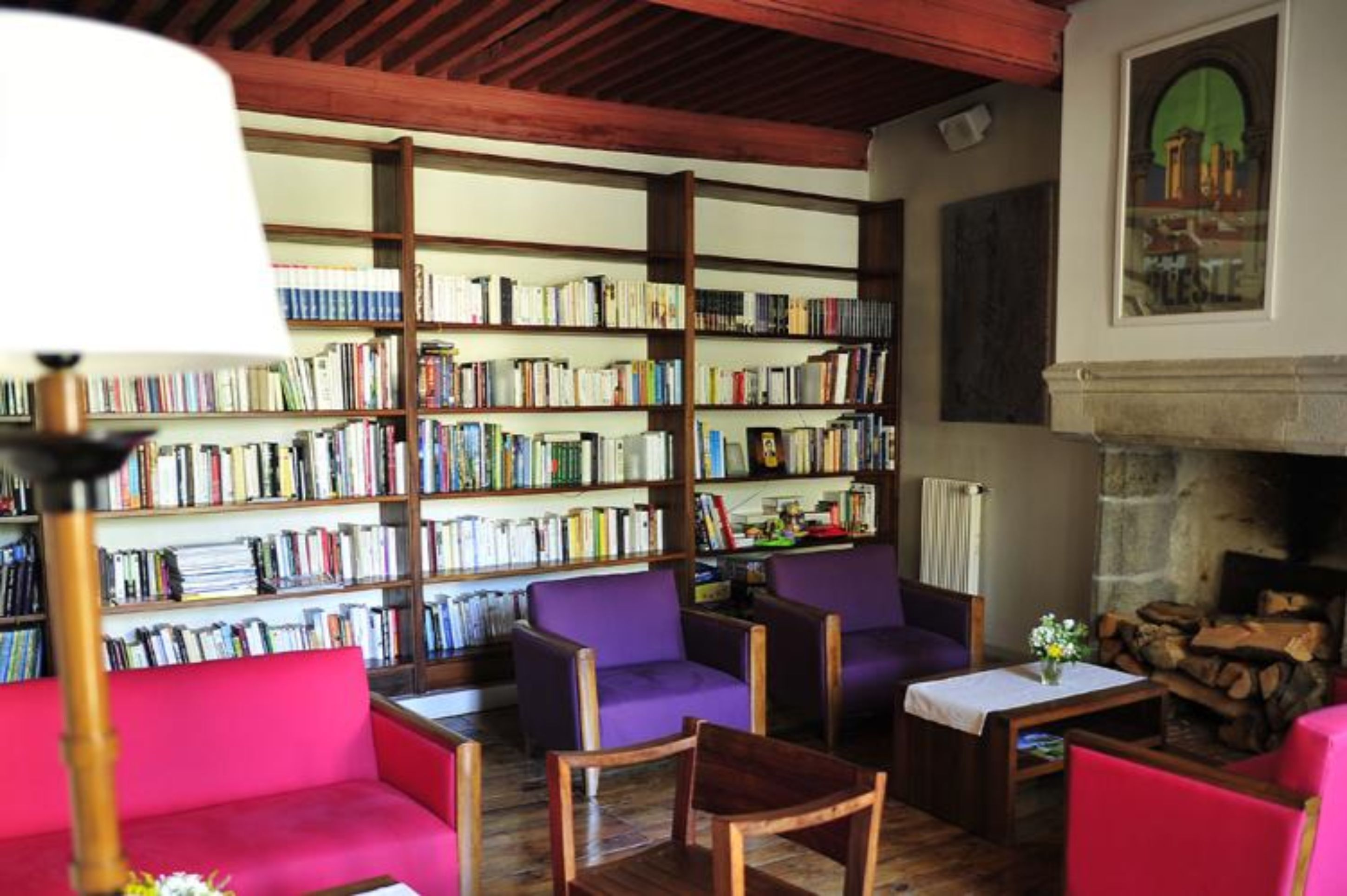 Una biblioteca acogedora con estanterías, asientos cómodos y una chimenea.