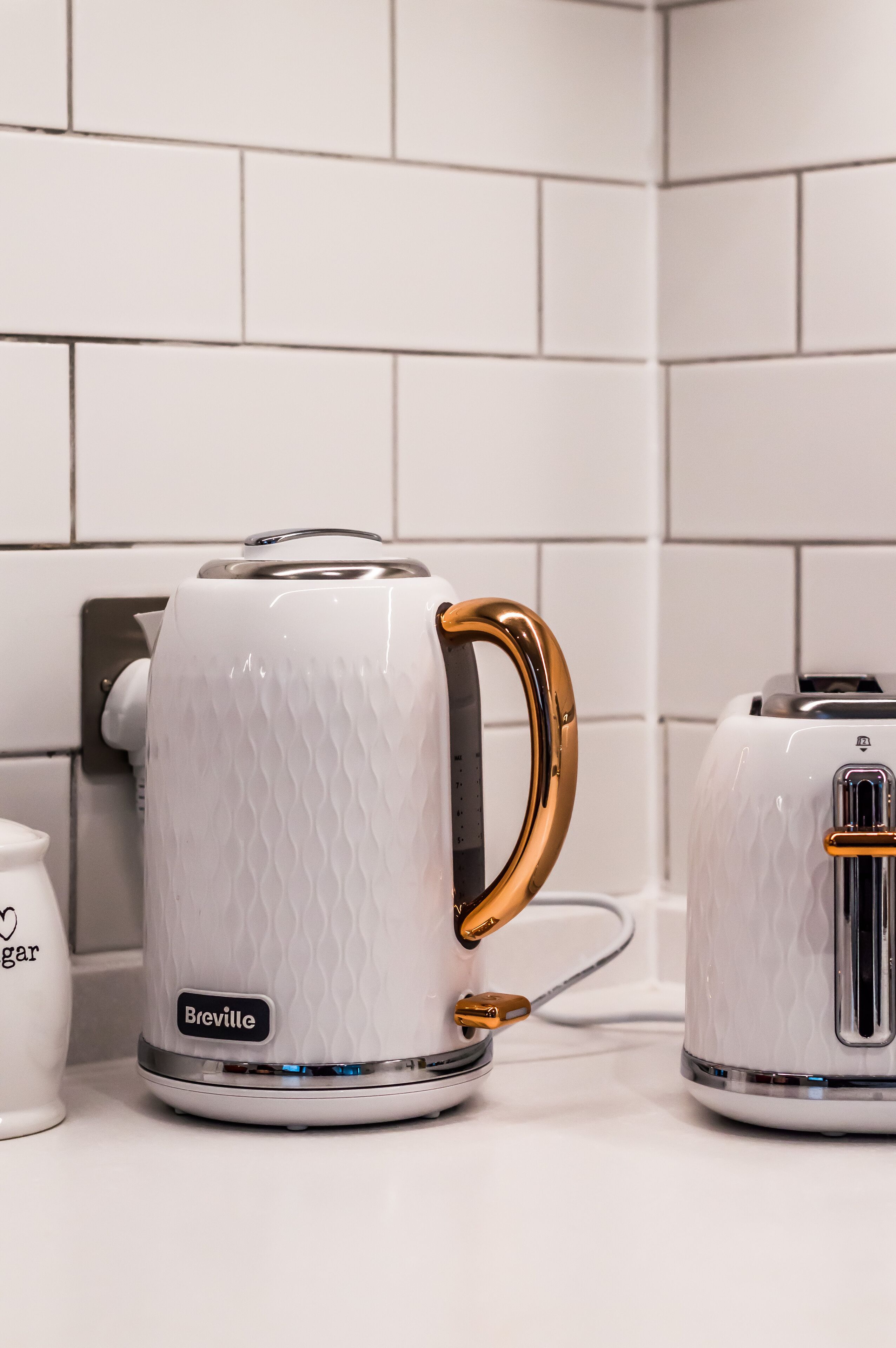 A Breville kettle with a gold handle on a kitchen counter.