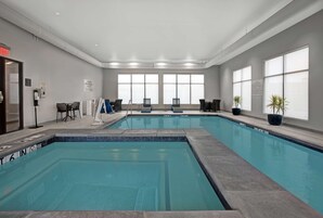 Una piscina techada, sillones reclinables de piscina