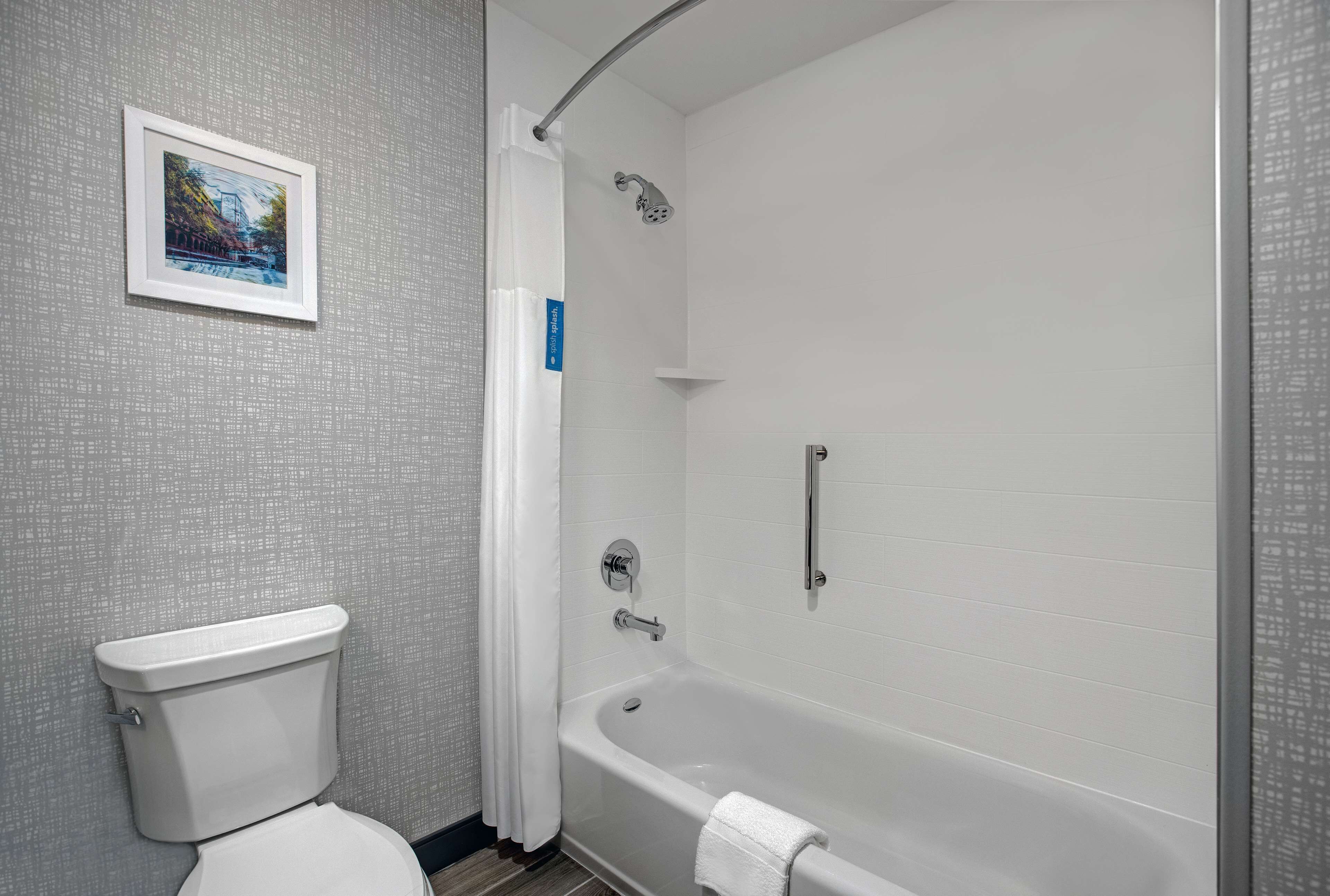 A bathroom with a toilet, a bathtub, and a shower.
