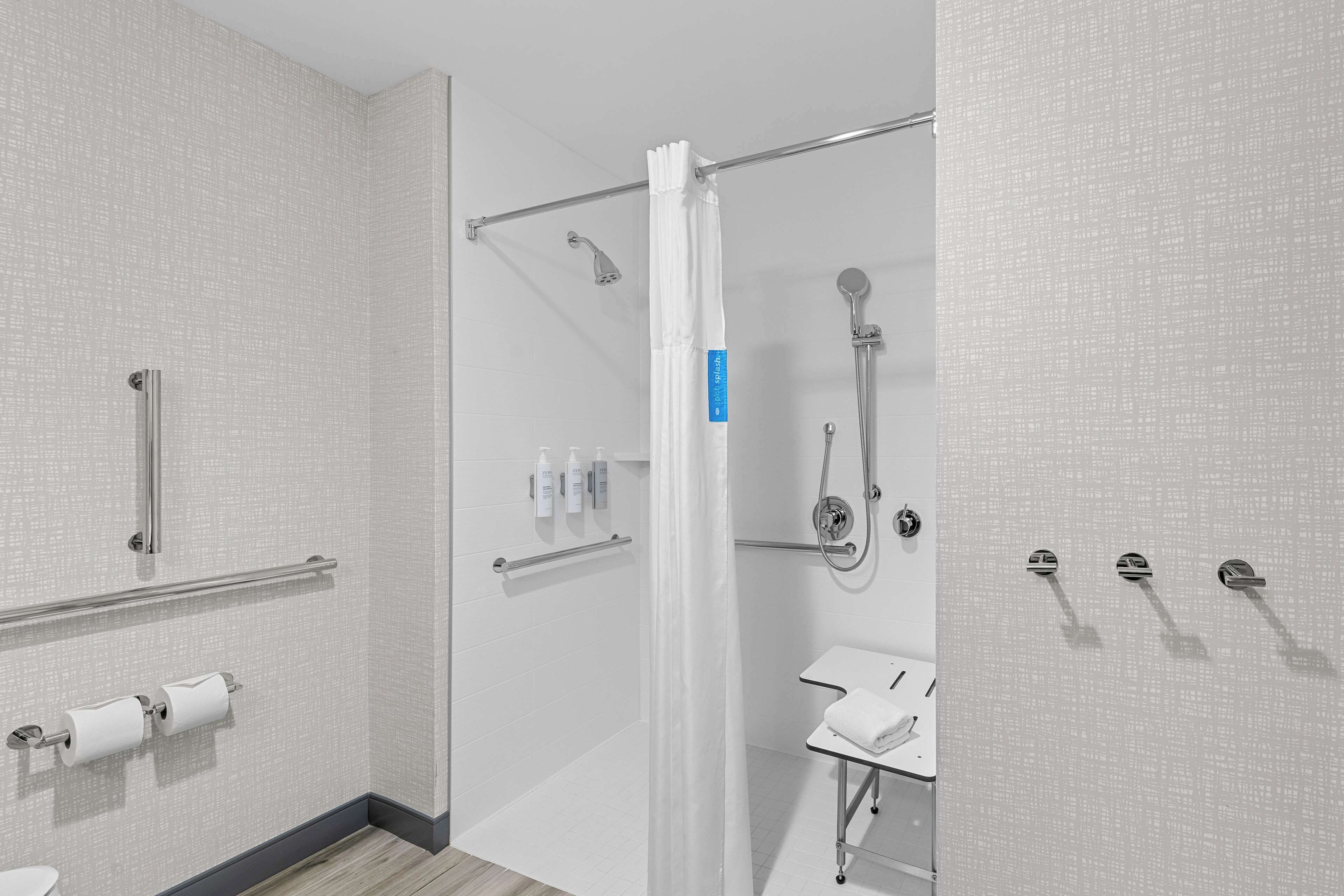 A modern bathroom with a shower, toilet, and sink.