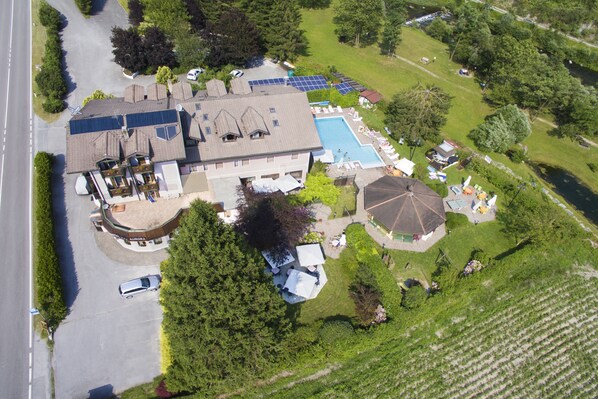 A large house with a swimming pool, solar panels, and a well-maintained lawn. - Albergo Ristorante Aurora (Borgo Chiese)