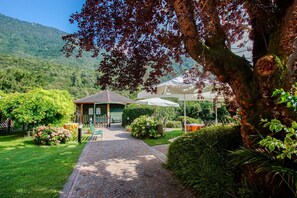 A garden pathway leading to a gazebo with a view of a mountain. - Albergo Ristorante Aurora (Borgo Chiese)