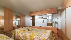 A modern bedroom with a large bed, a built-in wardrobe, and a bedside table. - Villa Gloria (Pietrasanta)