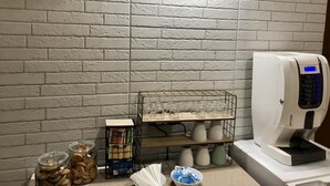 A kitchen area with a coffee machine, jars of cookies, and a shelf with glasses. - A Due Passi dal Ponte (Taranto)