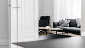 Ein modernes Wohnzimmer mit einem grauen Sofa, einem schwarzen Sessel und einem Couchtisch aus Holz.