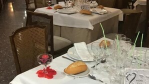 Un restaurante con mesas largas preparadas para comer, un letrero con la palabra 'LOVE' en la pared y un letrero con la palabra 'Sola' sobre la mesa.