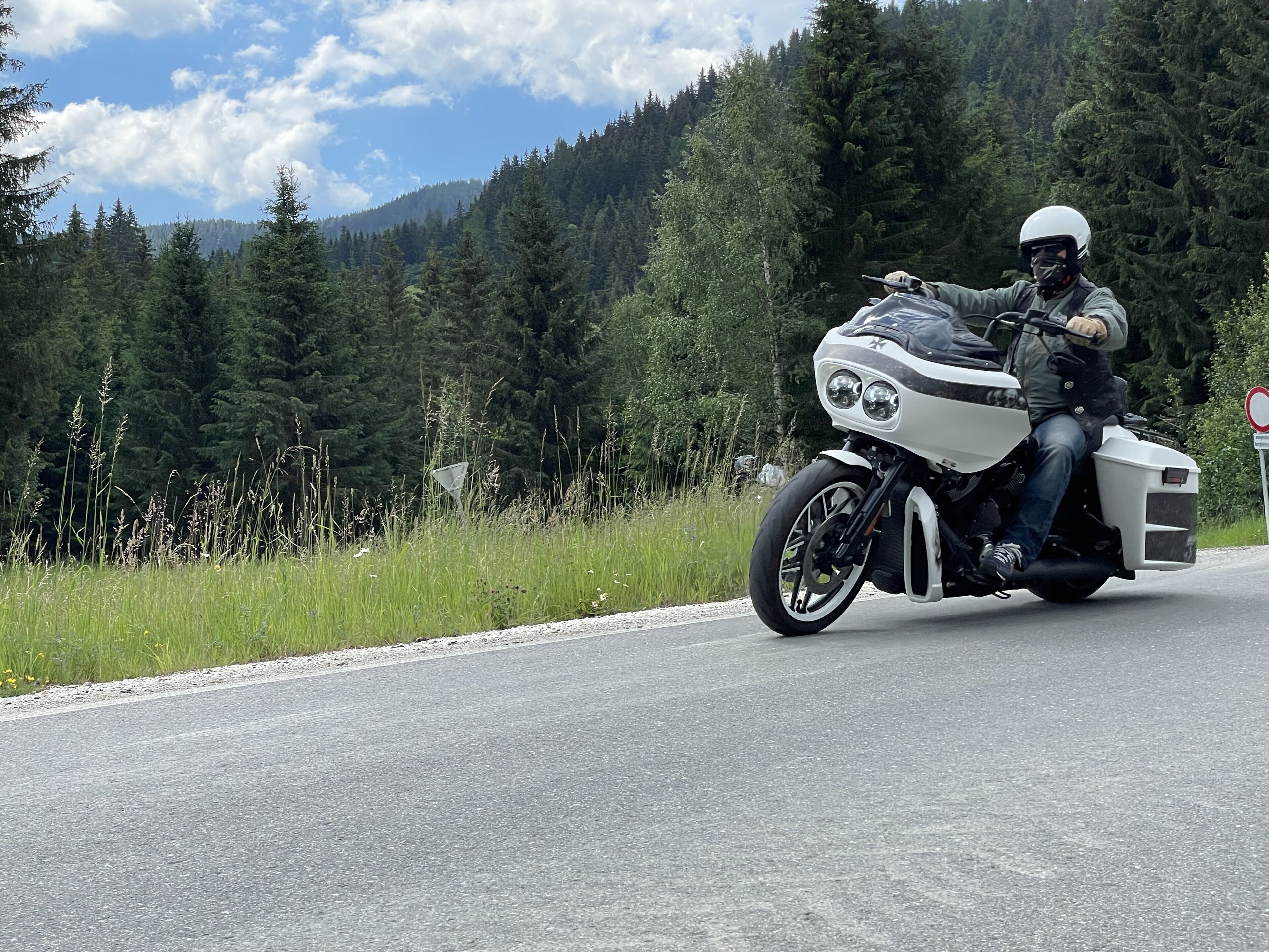 A motorcycle on a road with a forested mountain background.