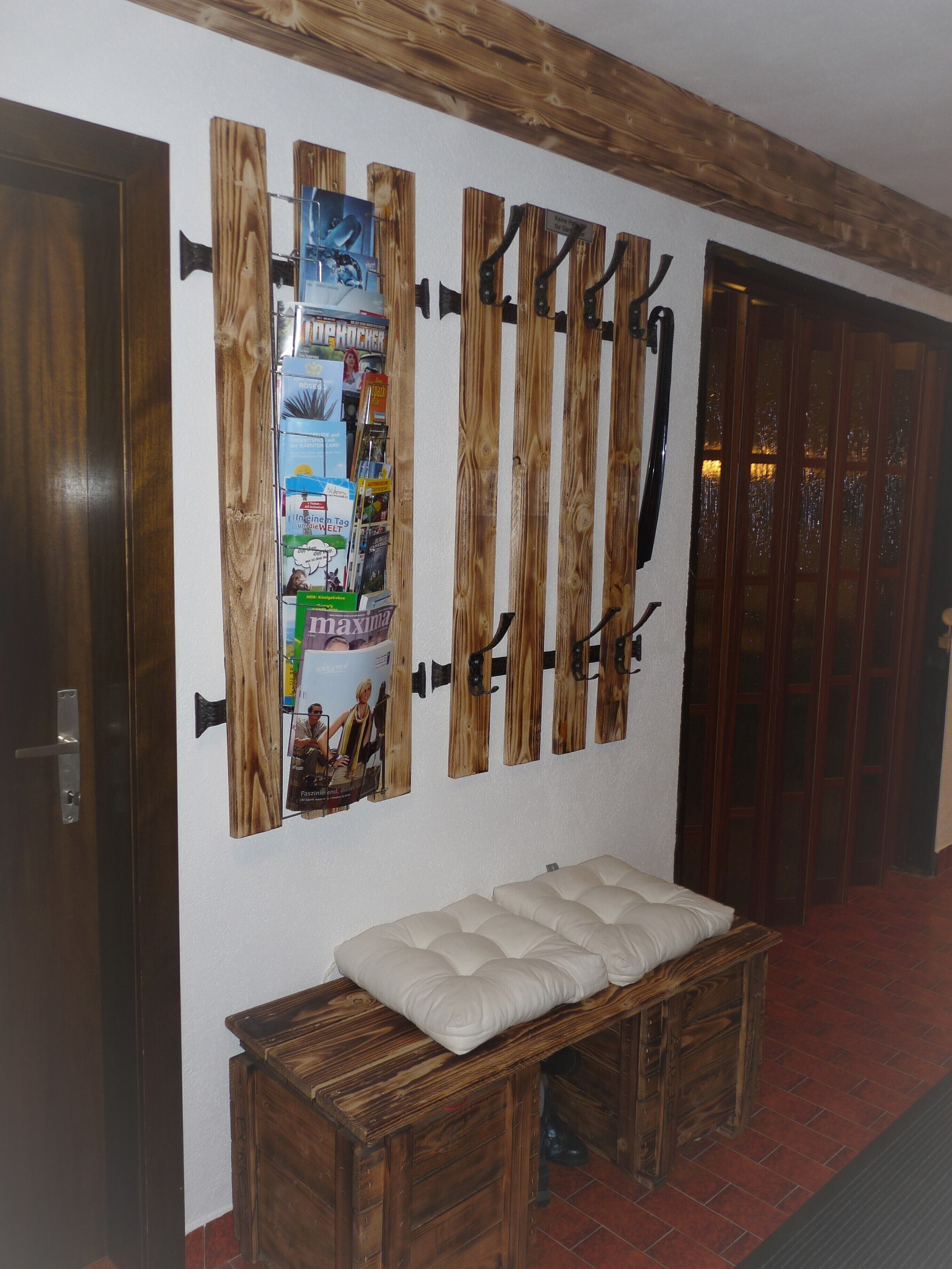 Una habitación con un banco de madera, un colgador de cuchillos en la pared y una puerta con panel de vidrio.